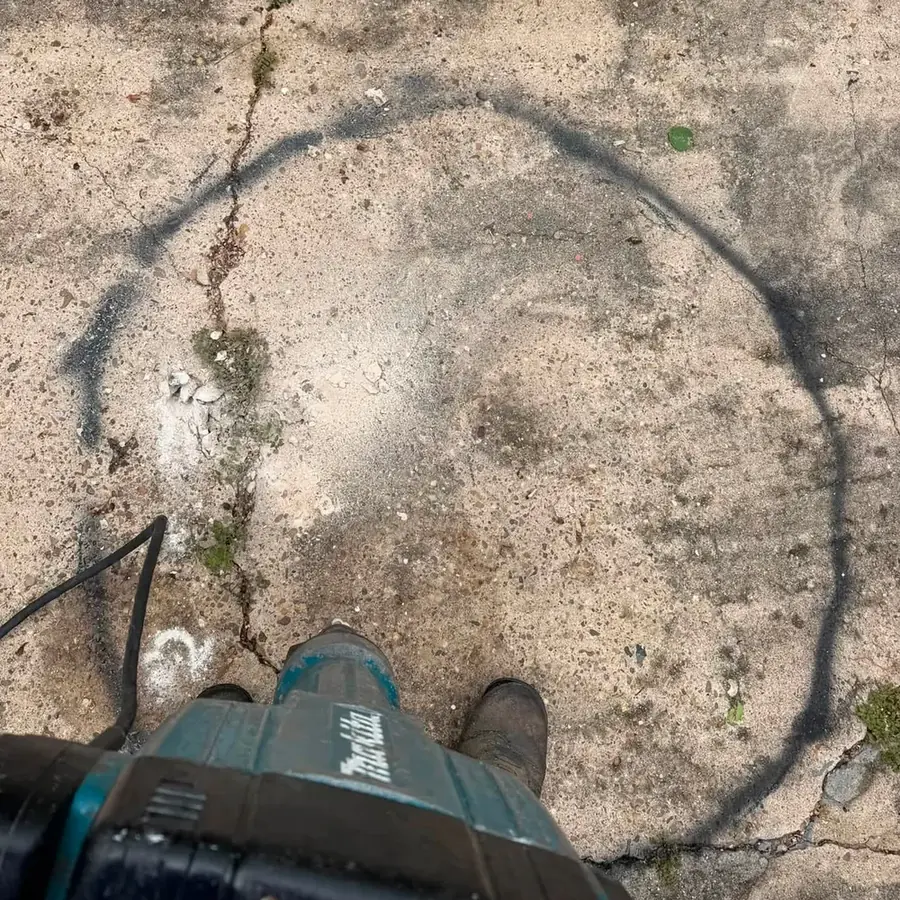 A solid concrete slab marked with a spray-painted circle before the cut