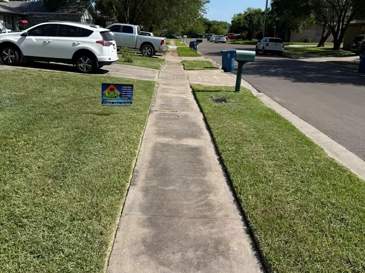 The same sidewalk after the visit — mowed and edged clean to the concrete, with an LRT sign in the yard