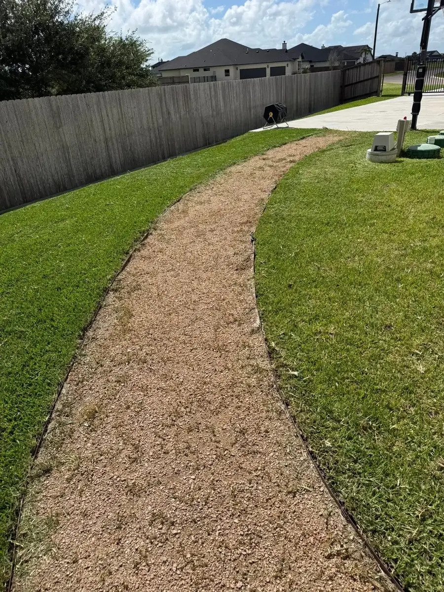 A curved decomposed granite walkway running through thick green turf