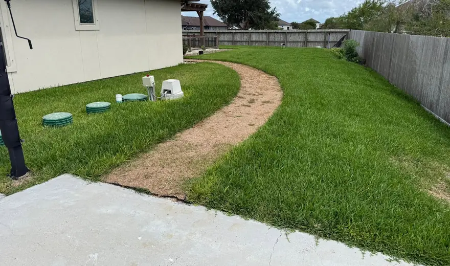 A curved decomposed granite walkway installed through fresh sod